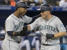 Kyle Seager, right, of the Seattle Mariners is all smiles as he's congratulated by Jean Segura after hitting a first inning grand slam in MLB action Thursday night at Rogers Centre. Seager had a pair of homers in the Mariners 9-3 victory.