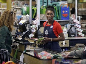 In this May 8, 2018, photo, Nadine Vixama, who emigrated from Haiti eight years ago, works as a cashier at a Whole Foods in Cambridge, Mass. Vixama has taken English classes and a program in store and customer service basics to gain work skills in retail. "I've learned to treat customers in a better way ... how to keep pace with them," Vixama said.