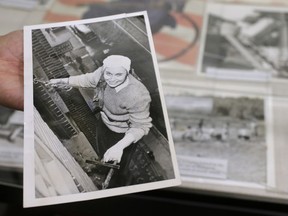 In this Monday, May 21, 2018, photo, Sue Wilkins, director of education at The International Museum of World War II, holds a 1945 newspaper photograph at the museum, in Natick, Mass., that shows Fern Corbett, 24, working as a window washer 10 floors above a Minneapolis street during World War II. Corbett worked as her company's stenographer before filling in as a window washer due to the absence of male workers during the war. The photograph is part of a new exhibit called: "Women in WWII: On the Home Fronts and the Battlefronts" that explores the important and unconventional roles women played in every large nation that fought in World War II.