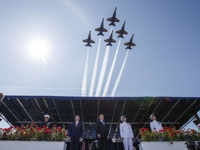 President Donald Trump looks on as the Blue Angels fly over the graduation ceremony at the U.S. Naval Academy, Friday, May 25, 2018, in Annapolis, Md.