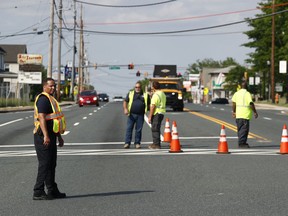 Officials guard a roadblock near a scene where a Baltimore County police officer died, while investigating a suspicious vehicle, Monday, May 21, 2018, in Perry Hall, Md. Heavily armed police swarmed into the leafy suburb, searching for at least one armed suspect.