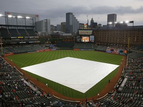A tarp covers the infield before a baseball game between the New York Yankees and the Baltimore Orioles, Thursday, May 31, 2018, in Baltimore. The start of the game was delayed because of rain in the area.