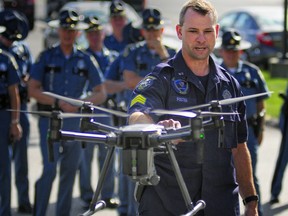 FILE – In this Sept. 28, 2017, file photo, Maine State Police Sgt. Darren Foster discusses the collision avoidance system on an unmanned aerial vehicle used for traffic accident investigations, while speaking outside Maine State Police headquarters at the Central Maine Commerce Center in Augusta, Maine. The number of public safety agencies with drones has more than doubled from the end of 2016 to 2018, according to data collected by the Center for the Study of the Drone at New York's Bard College, which estimates just over 900 police, sheriff, fire and emergency agencies now have drones, with California, Texas and Wisconsin leading the way.