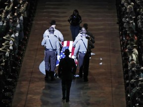 The casket of Cpl. Eugene Cole is brought into the funeral service at the Cross Insurance Center, Monday, May 7, 2018, in Bangor, Maine. Cole, a sheriff's deputy, was the first officer to be killed in the line of duty in Maine in early 30 years when he was killed early on April 25 in Norridgewock.