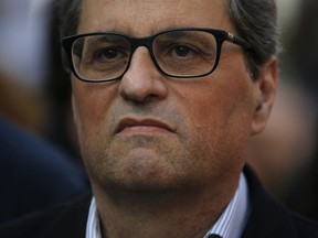 Newly appointed Catalan president Quim Torra, center, looks on during a protest in support of the imprisoned politicians, in center Barcelona, Spain, Wednesday, May 16, 2018. Separatist lawmakers defied court orders and held an ad-hoc referendum on independence in October. Their subsequent declaration of independence for the region led to a crackdown by Spanish authorities acting to defend the Spanish Constitution, which declares the nation "indivisible. Banners read in Catalan: "Republic is freedom".