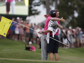 Webb Simpson and his caddie Paul Tesori congratulate each other after winning The Players Championship golf tournament Sunday, May 13, 2018, in Ponte Vedra Beach, Fla.