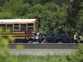 Emergency personnel attend to an accident involving a school bus, tow truck and SUV on eastbound I-94 near M-23 Tuesday, May 29, 2018 in Pittsfield Township, Mich. Police say a tow-truck driver was killed when an SUV slammed into the rear of an empty school bus as he tended to the broken down vehicle