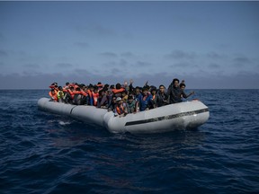 Refugees and migrants wait to be rescued by members of the Spanish NGO Proactiva Open Arms, after leaving Libya trying to reach European soil aboard an overcrowded rubber boat, north of Libyan coast, Sunday, May 6, 2018.