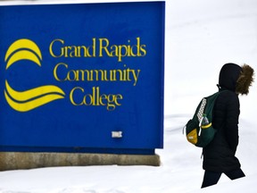 In this Feb. 20, 2015, file photo, a woman walks up Lyon Street near Grand Rapids Community College in Grand Rapids, Mich. College students who suddenly are in need of temporary financial help have a few resources to turn to. For example, at Grand Rapids Community College, assistance is available for students who face emergencies such as losing their job, eviction or utility shut-off