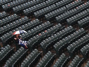 Detroit Tigers fans sit in the stands under an umbrella in the rain before the team's baseball game against the Seattle Mariners in Detroit, Friday, May 11, 2018.