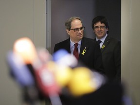 Former Catalan leader Carles Puigdemont, right, and Catalan president Quim Torra, left, arrive for a news conference in Berlin, Germany, Tuesday, May 15, 2018.