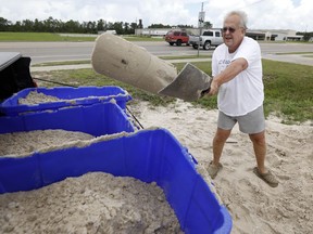 George Estes tosses sand into storage tubs at a Harrison County Road Department sand bagging location, that he will take back to his law office in downtown Gulfport, Miss., and will enlist help to fill bags that he will place by his office doors and plate glass window, while preparing for Subtropical Storm Alberto to make its way through the Gulf of Mexico in Gulfport, Miss., Saturday, May 26, 2018. The slow moving storm is threatening to bring heavy rainfall, storm surges, high wind and flash flooding this holiday weekend.