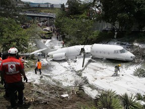 A white Gulfstream jet that appears broken in half near the center, lies engulfed in foam sprayed by firefighters, in Tegucigalpa, Honduras, Tuesday, May 22, 2018. The private jet crashed off the end of the runway at Tegucigalpa's airport Tuesday, but the crew and passengers were rescued and reportedly out of danger, according to Honduras emergency management agency.