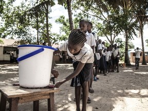 In this May 22, 2018 photo provided by UNICEF, schoolchildren wash their hands to help contain the Ebola outbreak before entering a classroom in the north-western city of Mbandaka, in Congo. Congo's health ministry announced six new confirmed Ebola cases and two new suspected cases Tuesday as vaccinations entered a second day in an effort to contain the deadly virus in the city of more than 1 million.