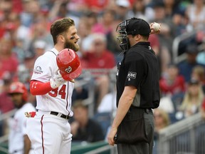 Washington Nationals' Bryce Harper (34) talks with home plate umpire Nic Lentz, right, after he was called out on strikes during the third inning of a baseball game against the Arizona Diamondbacks, Saturday, April 28, 2018, in Washington.