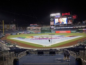 Tarp covers the infield during a rain delay during an interleague baseball game between the New York Yankees and Washington Nationals at Nationals Park, Tuesday, May 15, 2018, in Washington. The game was tied at 3-all when it was suspended due to a severe storms. The two teams will resume play tomorrow as part of a double-header.