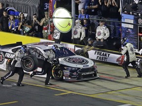 Crew members perform a pit stop on Kevin Harvick's car during the NASCAR All-Star auto race at Charlotte Motor Speedway in Concord, N.C., Saturday, May 19, 2018.
