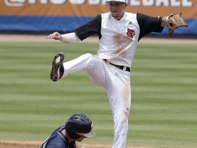 Pittsburgh's Nick Banman is out at second base as Louisville infielder Devin Mann jumps after making a throw to first base during the second inning of an Atlantic Coast Conference NCAA college baseball tournament semifinal game in Durham, N.C., Saturday, May 26, 2018.
