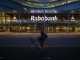 A cyclist passes the headquarters of Rabobank Groep illuminated at night in Utrehct, Netherlands, on Thursday, Oct. 24, 2013.