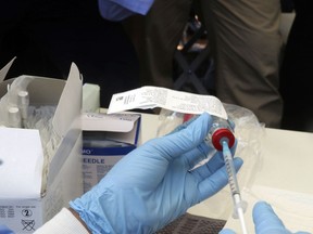 A health worker prepares an Ebola vaccine to administer to health workers during a vaccination campaign in Mbandaka, Congo, Monday, May 21, 2018. Congo's health minister says a nurse has died from Ebola in Bikoro, the rural northwestern town where the outbreak began, as the country begins a vaccination campaign.