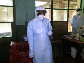 In this photo taken on Sunday, May 13, 2018, a health care worker wears virus protective gear at a treatment center in Bikoro Democratic Republic of Congo. Congo's latest Ebola outbreak has spread to a city of more than 1 million people, a worrying shift as the deadly virus risks traveling more easily in densely populated areas. Two suspected cases of hemorrhagic fever were reported in the Wangata health zones that include Mbandaka, the capital of northwestern Equateur province. The city is about 150 kilometers (93 miles) from Bikoro, the rural area where the outbreak was announced last week, said Congo's Health Minister Oly Ilunga.