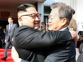 This picture taken on May 26, 2018 and released by the Blue House via Dong-A Ilbo shows South Korea's President Moon Jae-in (R) hugging North Korea's leader Kim Jong Un after their second summit at the north side of the truce village of Panmunjom in the Demilitarized Zone (DMZ). South Korea said President Moon Jae-in met with North Korea's leader Kim Jong Un on May 26 inside the Demilitarised Zone dividing the two nations, a day after US President Donald Trump threatened to abandon a summit with Pyongyang.