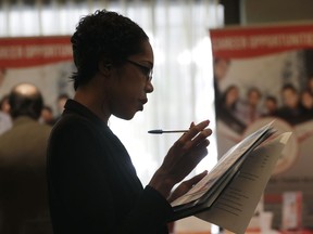 FILE - In this Jan. 30, 2018 file photo, Joana Dudley, of Lauderhill, Fla., looks at her list of job prospects at a JobNewsUSA job fair in Miami Lakes, Fla. U.S. businesses added 178,000 jobs in May 2018, according to a survey, a solid total but below last winter's average monthly gains. Payroll processor ADP says hiring was strong in construction, education and health care, and professional and business services, which includes accounting, engineering and legal services. Retailers cut jobs, the report said.