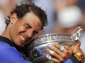 FILE - In this June 11, 2017, file photo, Spain's Rafael Nadal holds the trophy as he celebrates winning his 10th French Open title, after defeating Switzerland's Stan Wawrinka in three sets, 6-2, 6-3, 6-1, in the men's final match of the French Open tennis tournament at the Roland Garros stadium, in Paris, France.  Even as his 32nd birthday approaches, Nadal is as dominant a figure as anyone ever has been on a particular tennis surface.
