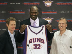 FILE - In this Feb. 7, 2008, file photo, Phoenix Suns' Shaquille O'Neal, center, holds up his new basketball jersey as he is flanked by Suns general manager Steve Kerr, left, and coach Mike D'Antoni at a news conference in Phoenix. Kerr praises D'Antoni for influencing the way NBA teams now play offense: the pace, the importance of precise ball movement, going small without a traditional center and shooting at will from way back.