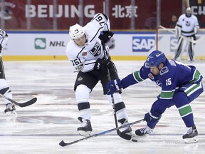 FILE - In this Sept. 23, 2017, file photo, Los Angeles Kings' Jonny Brodzinski, second from right, and the Vancouver Canucks' Derek Dorsett battle for control of the puck during the second period of their NHL China exhibition game at the Cadillac Arena in Beijing. The NHL is going back to China for two exhibition games this fall between the Boston Bruins and Calgary Flames. The league announced Wednesday, May 2, 2018, the Bruins and Flames will face off Sept. 15 in Shenzhen in southeast China and then again Sept. 19 in Beijing.