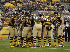 FILE - In this Sunday, Oct. 28, 2012 file photo, the Pittsburgh Steelers offense, wearing 1934 throwback uniforms, huddles during the first quarter of an NFL football game against the Washington Redskins in Pittsburgh. The Pittsburgh Steelers are ditching their "bumble bee" throwback uniforms for something with a more 1970s feel. The team announced it will wear replica jerseys of the 1978 and 1979 clubs that won Super Bowls when the Steelers host the Cleveland Browns on Oct. 28, 2018.