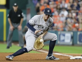 FILE - In this Oct. 14, 2017, file photo, New York Yankees' Greg Bird fields a grounder by Houston Astros' Brian McCann during the fifth inning of Game 2 of baseball's American League Championship Series in Houston. The Yankees plan to activate Bird from the disabled list before Saturday's game against the Los Angeles Angels, forcing New York to make a difficult roster decision. Bird has been sidelined since right ankle surgery on March 27.