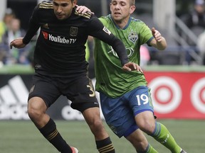 FILE - In this Sunday, March 4, 2018 file photo, Seattle Sounders forward Harry Shipp, right, challenges Los Angeles defender Steven Beitashour during the first half of an MLS soccer match in Seattle. The wait was short for LAFC defender Steven Beitashour, who was left off of Iran's World Cup latest roster less than a week after his name was intriguingly included on the national team's preliminary list. Beitashour had been hoping for his second trip to soccer's premier tournament.