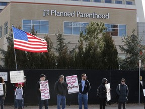 FILE - In this Saturday, Feb. 11, 2017 file photo, pro-choice counter-protesters hold signs supporting a woman's right to choose abortion, as nearby anti-abortion activists held a rally in front of Planned Parenthood of the Rocky Mountains in Denver. On Wednesday, May 2, 2018, two major organizations that promote birth control, including Planned Parenthood, filed lawsuits in federal court seeking to block the Trump administration from shifting national family planning policy in a conservative direction that would stress abstinence and potentially limit counseling for adolescents.