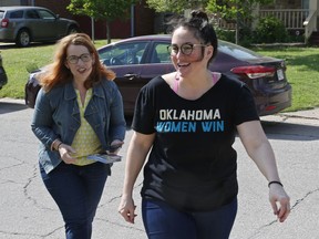 Chelsea Abney, right, walks with Danielle Ezell, Democratic state senate candidate, as they knock on doors in The Village, Okla., Saturday, May 12, 2018. Abney grew up surrounded by red. She was a reliable Republican herself until 2015, when she took an online quiz during the party's crowded presidential primary to see which candidate she should vote for. The quiz told her she was a Hillary Clinton voter.