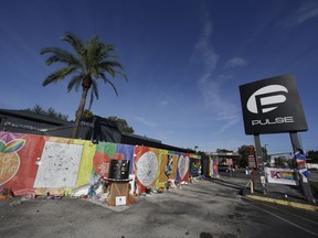 FILE - In this Nov. 30, 2016 file photo, artwork and signatures cover a fence around the Pulse nightclub, scene of a mass shooting, in Orlando, Fla. An interim memorial for the 49 people killed at the nightclub is opening to the public on Tuesday, May 8, 2018. The onePULSE Foundation said that the temporary memorial will open at 3 p.m., at the site of Pulse nightclub, which has remained closed since the June 2016 shooting.
