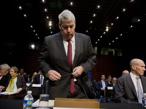 FILE - In this April 27, 2016, file photo, Valeant's outgoing CEO, J. Michael Pearson, standing, and former chief financial officer Howard Schiller, right, arrive on Capitol Hill in Washington, to testify before the Senate Special Committee on Aging hearing on drastic price hikes by Valeant and a handful of other drugmakers that have stoked outrage from patients, physicians and politicians nationwide. Pearson, who formulated the strategy, was ousted in 2016.