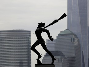 FILE - In this May 4, 2018, file photo, buildings in Lower Manhattan provide a backdrop to a statue dedicated to the victims of the Katyn massacre of 1940, in Jersey City, N.J. Jersey City Mayor Steve Fulop and local Polish groups announced late Saturday that they have reached an agreement on relocating the Katyn Memorial. Details on the deal will be announced during a news conference Monday, May 14.
