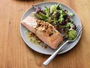 This Jan. 24, 2017, photo provided by America's Test Kitchen shows Salmon with Almond Vinaigrette in Brookline, Mass. This recipe appears in "Cooking at Home with Bridget & Julia."