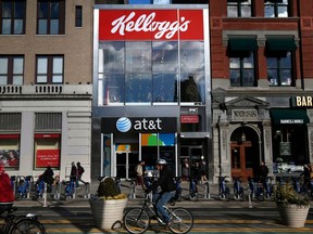 FILE- In this Dec. 14, 2017, file photo, people bike and walk by Kellogg's NYC Cafe at Union Square in New York. Kellogg Co. reports earnings Thursday, May 3, 2018.