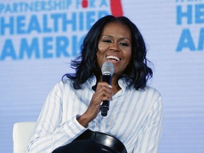 FILE - In this May 12, 2017, file photo, former first lady Michelle Obama smiles while speaking at the Partnership for a Healthier American 2017 Healthier Future Summit in Washington. The former first lady will be joined by a lineup of celebrities when she honors Philadelphia students for their pursuit of a college education or career in the military for College Signing Day. The event Wednesday, May 2, 2018, in Philadelphia is the fifth College Signing Day she's hosted.
