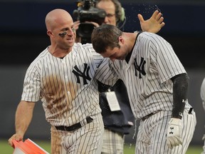 New York Yankees' Brett Gardner, left, congratulates Neil Walker after Walker drove in the winning run against the Oakland Athletics during the eleventh inning of a baseball game, Saturday, May 12, 2018, in New York. The Yankees won 7-6.