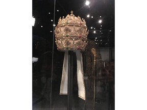 In a May 5, 2018 photo, a jewel-encrusted papal tiara from the Sistine Chapel sacristy at the Vatican, is displayed at the Metropolitan Museum of Art in its "Heavenly Bodies: Fashion and the Catholic Imagination," the spring fashion exhibit at the museum's Costume Institute.