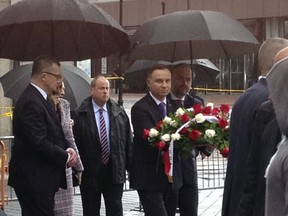 The president of Poland, Andrzej Duda, center, carries a bouquet of roses toward the waterfront statue commemorating the 1940 Soviet massacre of Poles, Wednesday, May 16, 2018. The bronze statue depicting a Polish soldier gagged, bound and impaled in the back with a bayonet in the 1940 Soviet massacre will be moved to a new location on the Hudson River, sparing it from storage and an uncertain fate. The statue was originally supposed to be placed in storage but that decision drew the ire of local Polish-American groups.