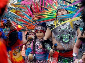 FILE - In this Monday, May 1, 2017, file photo, members of Ce Atl, an Aztec-inspired spiritual and cultural preservation group, dance near the front of a march for worker and immigrant rights at a May Day event in Seattle. The Donald Trump era has been everything that immigrant rights' groups feared, but while they are taking to the streets again for May Day rallies in solidarity with those around the world, their focus this year is less on a huge turnout on a Tuesday in May than the first Tuesday in November.