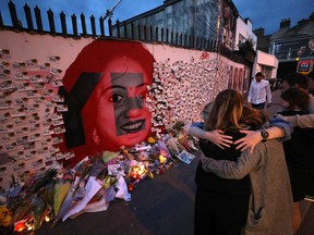 Candle and flowers are placed in front of a mural of Savita Halappanavar in Dublin, Ireland, Saturday, May 26, 2018, as Ireland has voted to repeal the 8th Amendment of the Irish Constitution which prohibits abortions unless a mother's life is in danger.