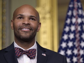 FILE - In a Tuesday, Sept. 5, 2017 file photo, Dr. Jerome Adams waits to be sworn in as the 20th U.S. Surgeon General by Vice President Mike Pence in Washington. Adams says he gave assistance to someone on a Delta Air Lines flight Wednesday, May 16, 2018, to Jackson, Mississippi.