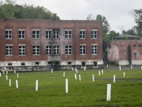 In this May 23, 2018 photo, each white marker denotes a mass grave of about 150 people on Hart Island in New York. Officials let reporters get a rare look at Hart Island, the place that has served as New York City's potter's field for 150 years.