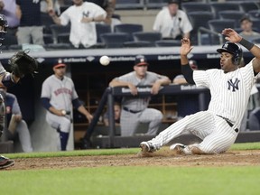 New York Yankees' Miguel Andujar slides home with the winning run on a single by Gleyber Torres as Houston Astros catcher Max Stassi waits for the throw during the 10th inning of a baseball game Tuesday, May 29, 2018, in New York.