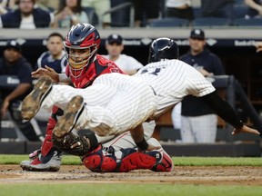 Los Angeles Angels catcher Martin Maldonado, left, tags out New York Yankees' Aaron Hicks at home plate during the second inning of a baseball game Friday, May 25, 2018, in New York.